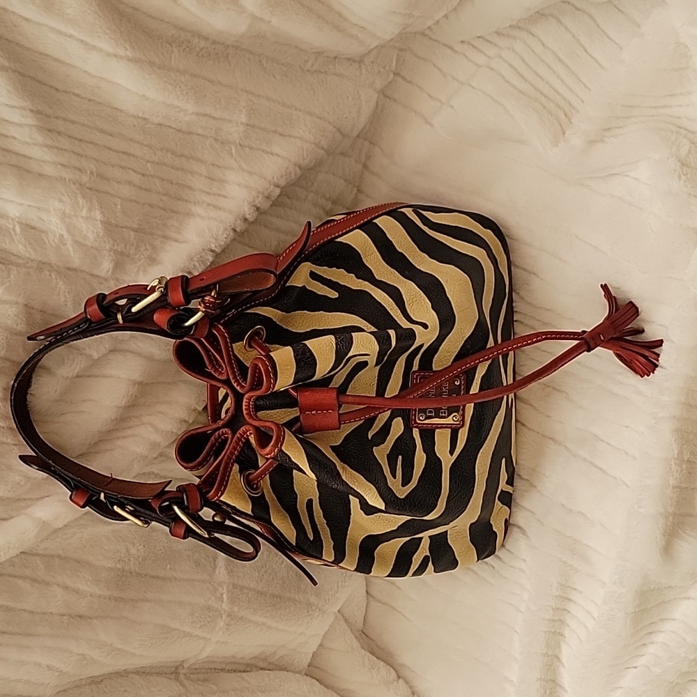 Dooney & Burke Leather Zebra Print drawstring Bucket Bag with Red Leather Trim.